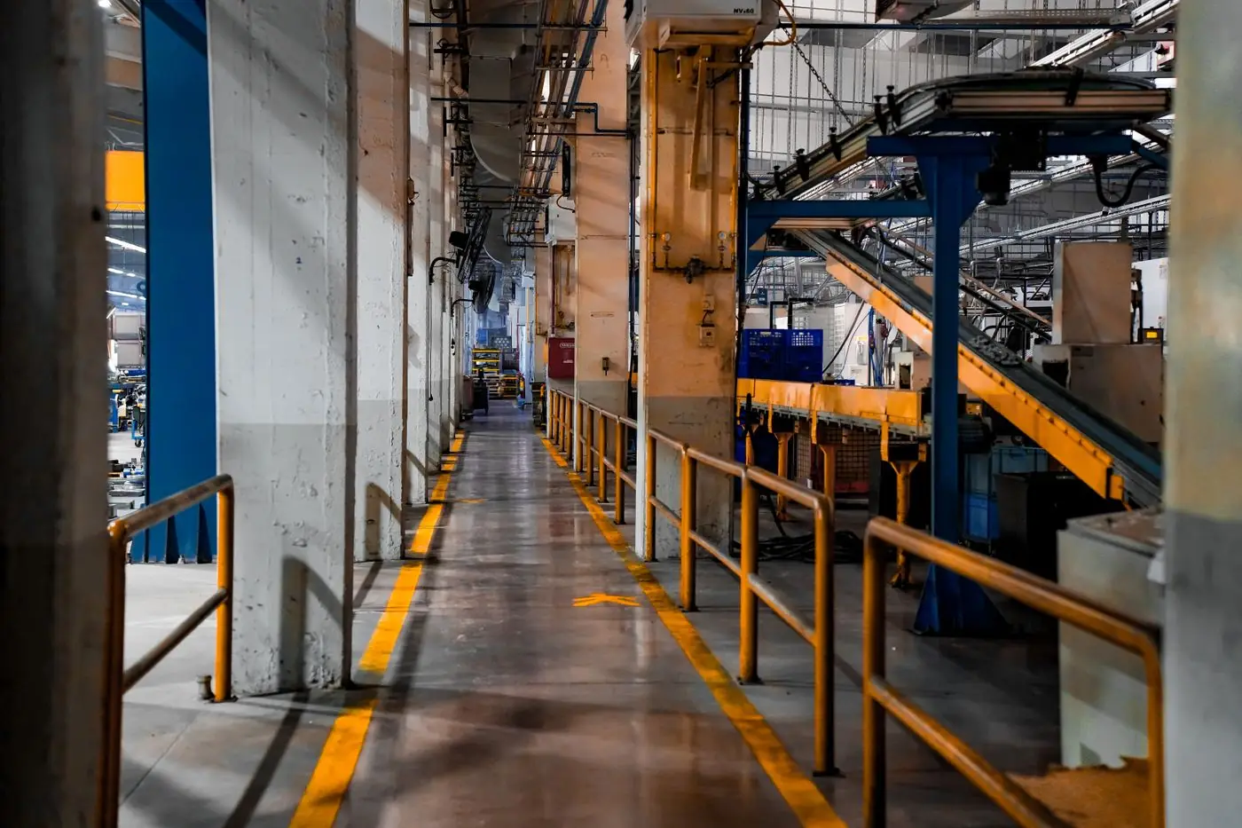 Allée de circulation dans une usine équipée de convoyeurs